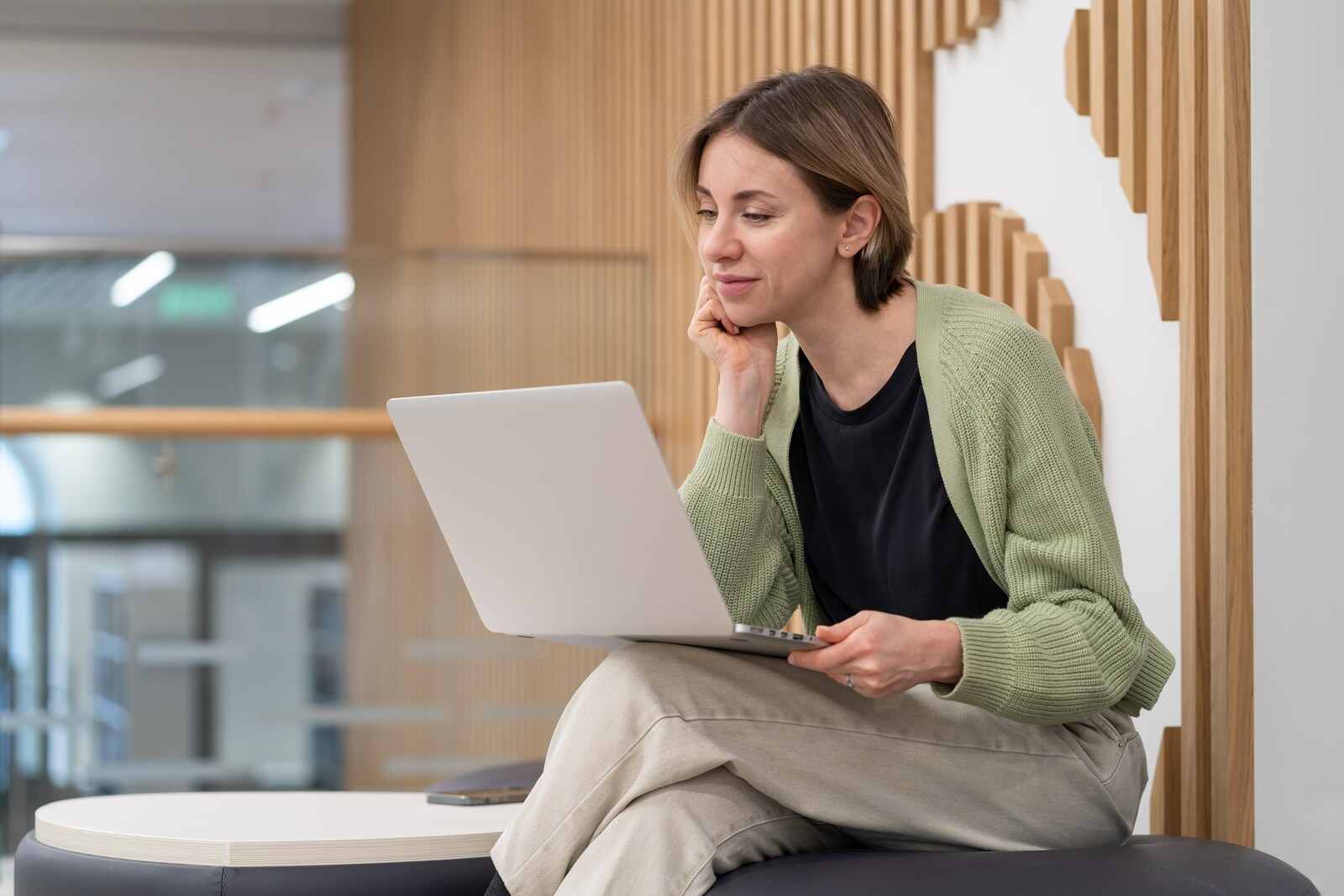 Mujer revisando su portátil en espacio de oficina